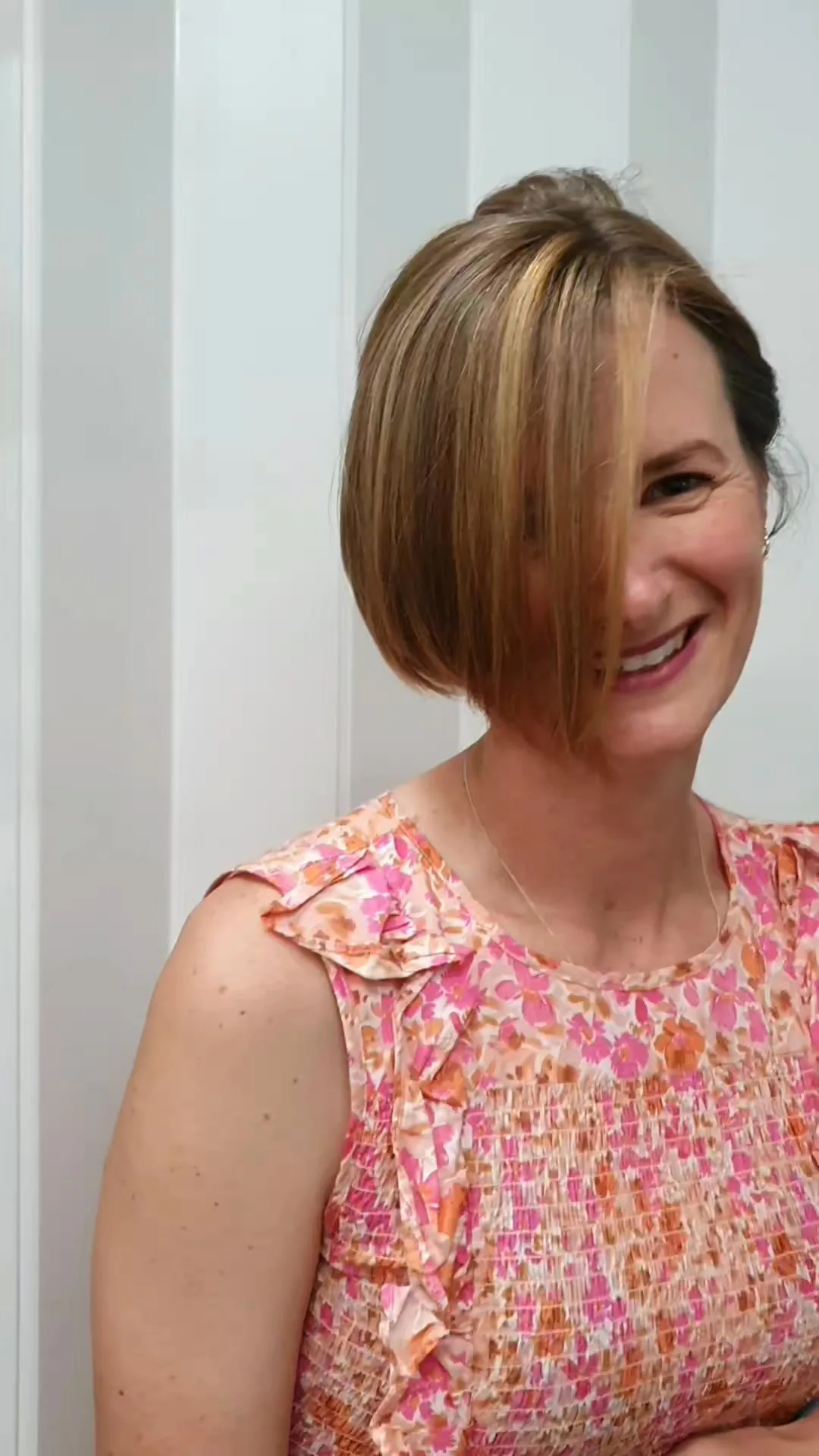 Copper-blonde bob, client mid-laugh, white shiplap wall