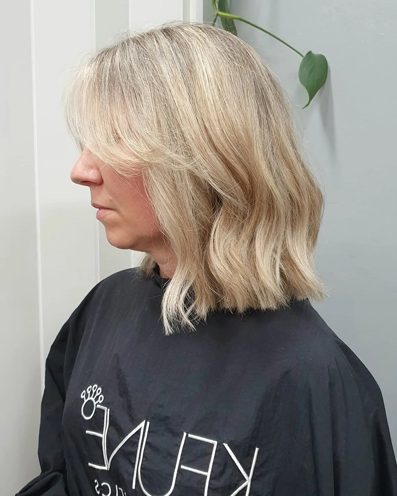 Blonde textured lob, white panelled wall, trailing plant