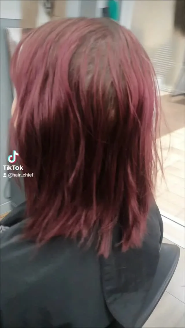 Burgundy-red wavy lob, back view, salon interior