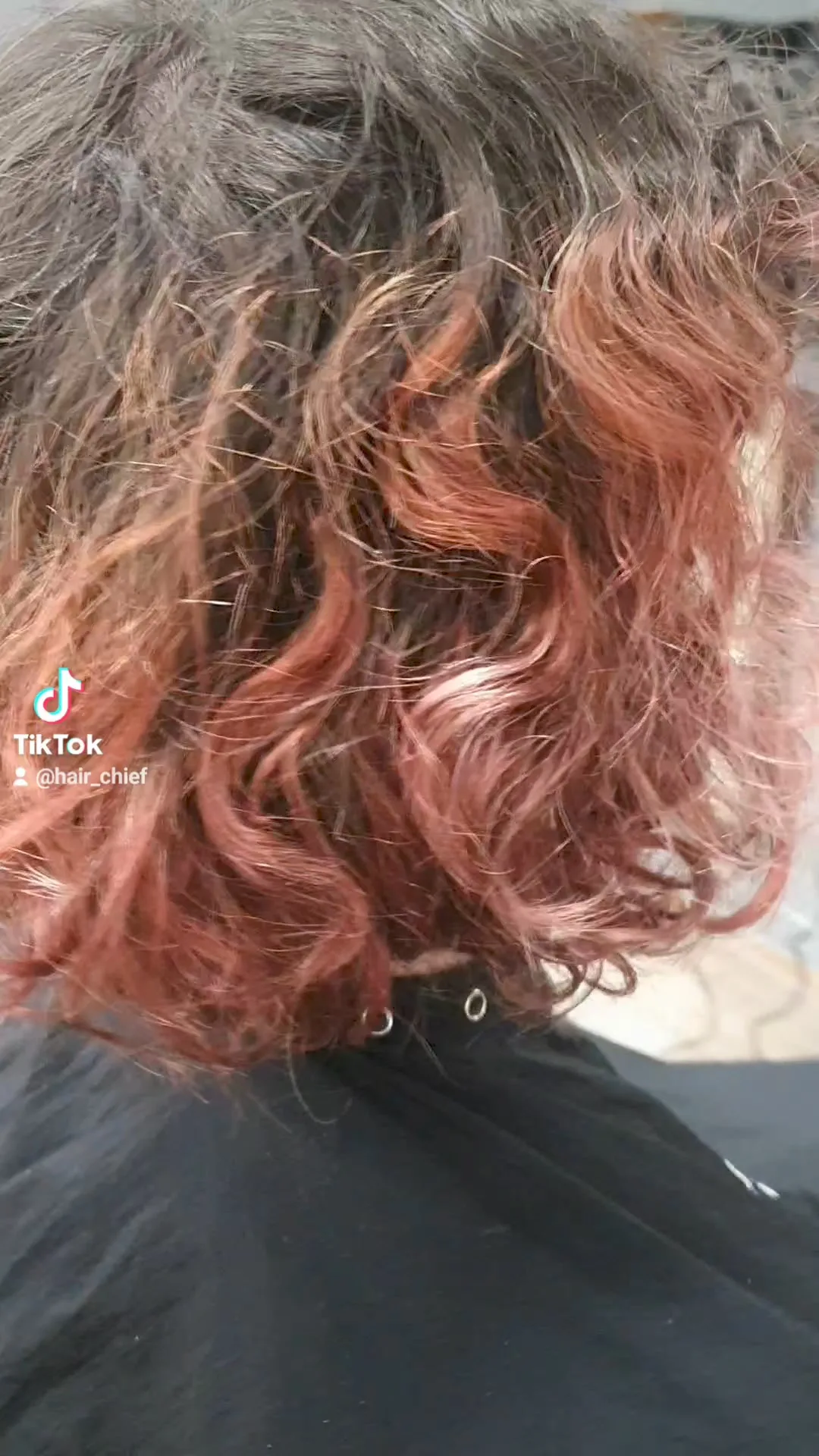 Rose-auburn wavy balayage, back of head, black cape